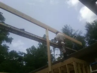 Carpenter setting a ridge beam over a new addition frame — Ice Dam Removal by Roofing Brothers in Cooperstown